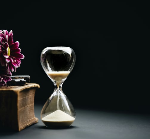 a hourglass, book and a flower
