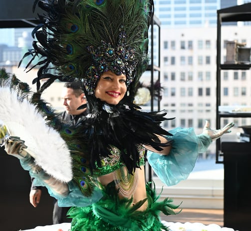 a woman in a green dress with feathers on a table