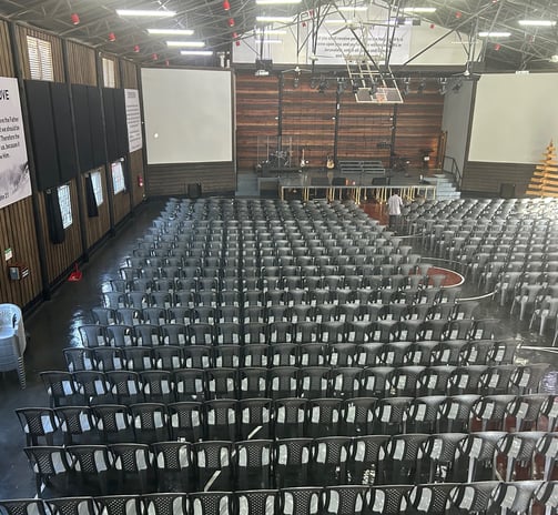 a large room with rows of chairs and a projector