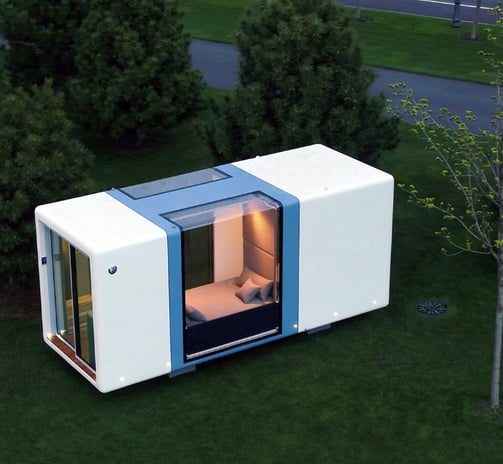 Futuristic tiny home pod with glass walls in green space