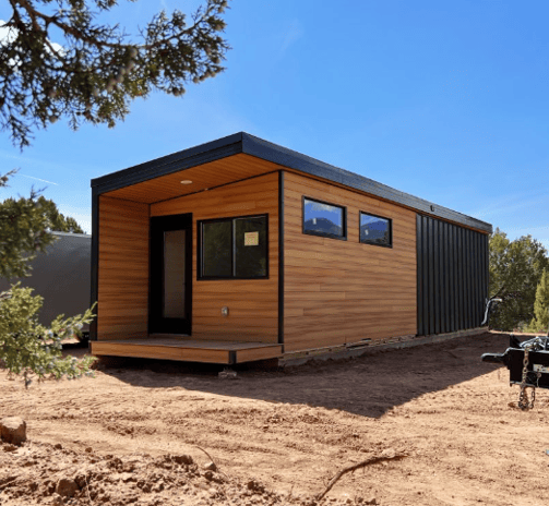 Modern tiny home pod with wood siding and black trim