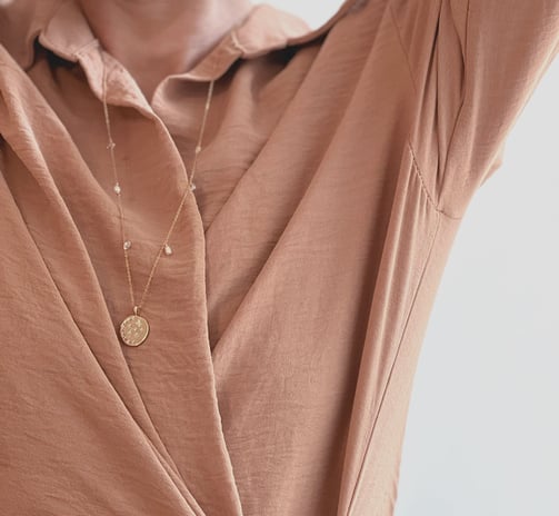 Photo portée d'un collier BYNORA en gold filled jaune et pierres naturelles