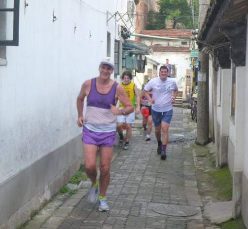 men running in a narrow alley