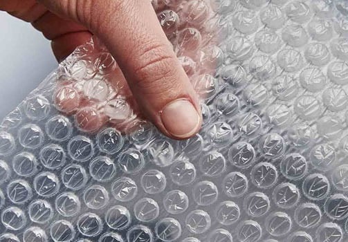 a person holding a piece of bubble bubble wrap