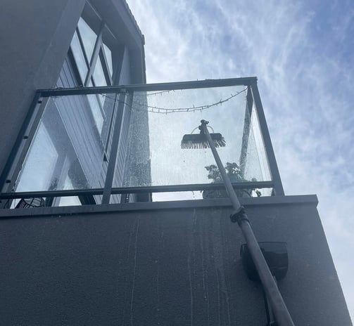 outdoor cleaning services Fife - exterior glass balcony being cleaned with an extendable brush
