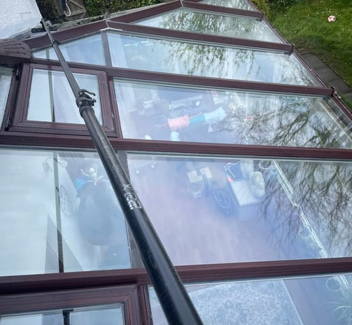 outdoor cleaning services Fife - extendable brush cleaning a glass conservatory roof