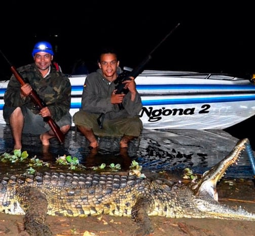 two men are holding guns and a gun in the water