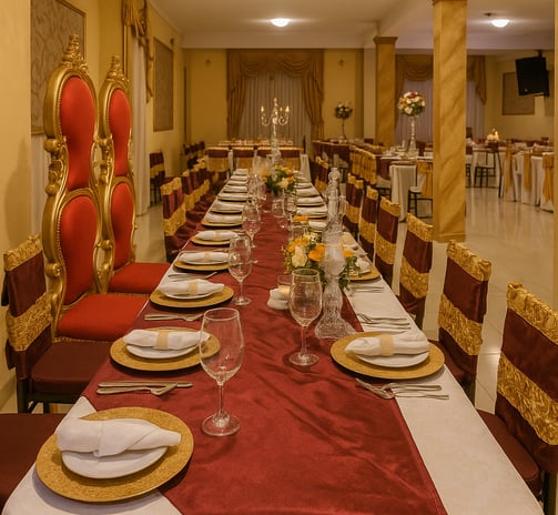 Mesa larga con sillas de respaldo rojo y detalles dorados, preparada Magic Party, Quito