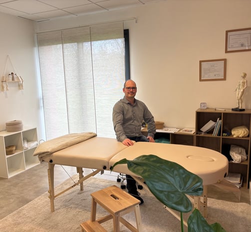 The patrician in front of his massage table in his office