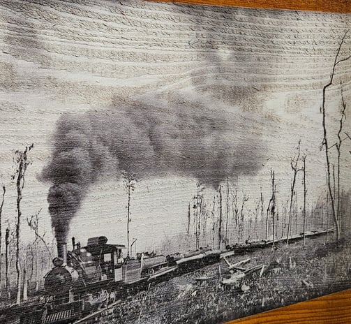 a black and white photograph of a train engine on wood