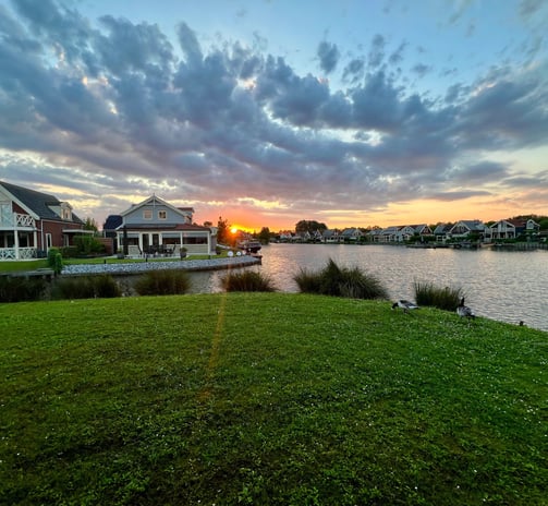 a sunset over a lake with a boat in the foreground, Zuytland-Buiten Simonshaven, Zuid-Holland