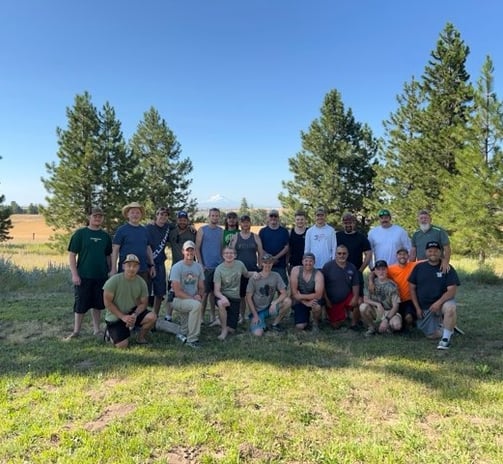 a group of people standing in a field with trees