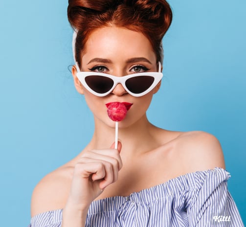 a woman with sunglasses and lollipop on a blue background