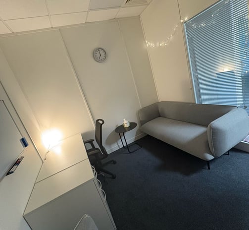 Therapy room: sofa on the right with fairy lights above, viewpoint from counselling chair