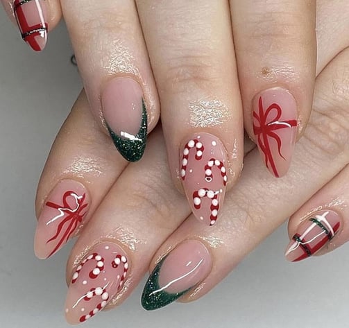 Uñas con diseño de bastones y lazos navideños
