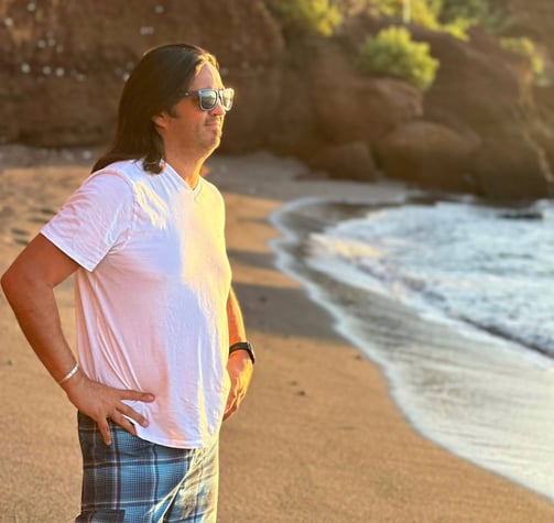 a man standing on a beach with a surfboard