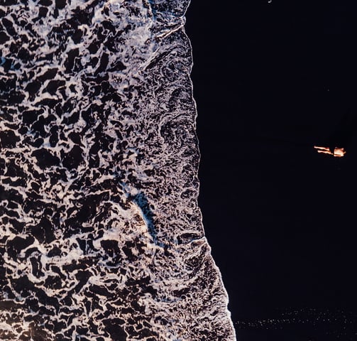 a person standing on a beach with a surfboard
