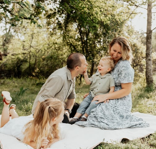 a family of four sitting on a blanket