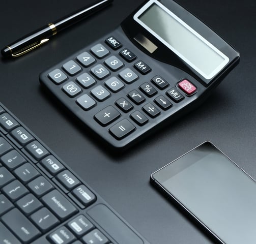 a calculator and a cell phone on a desk