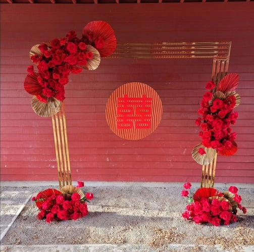 Double happiness signage with a gold chrome backdrop and red roses