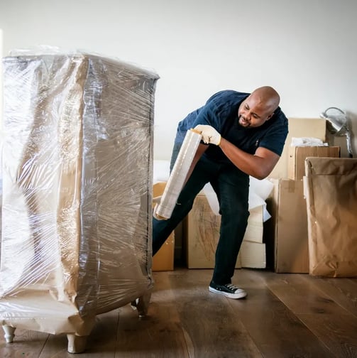 a man moving a couch with a mattress on it