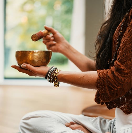 woman in brown knit sweater holding brown ceramic bowl