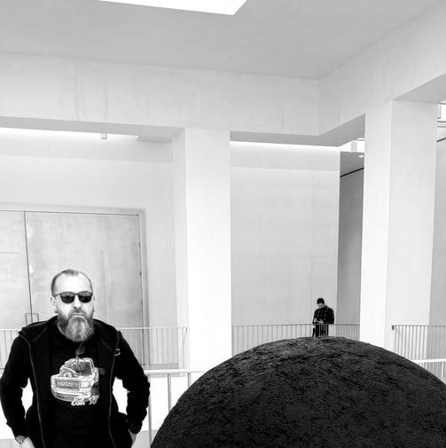 JEWELLER standing in front of a large black object