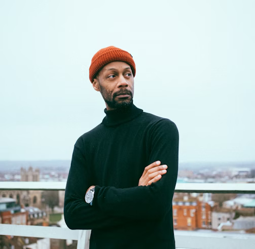 a man in a black sweater and a red hat