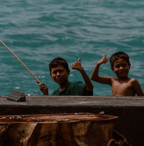 two boys in a boat on the water