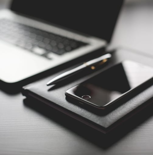 a laptop and a cell phone on a desk