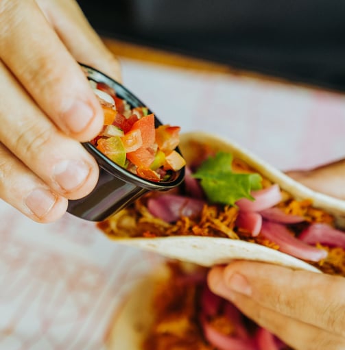 Taco con carne desmechada y pico de gallo en Santa Lola