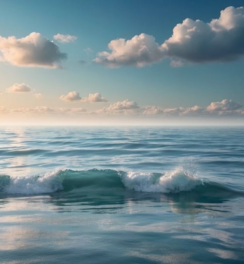 Image of waves crashing on a beach beneath a sunny sky.