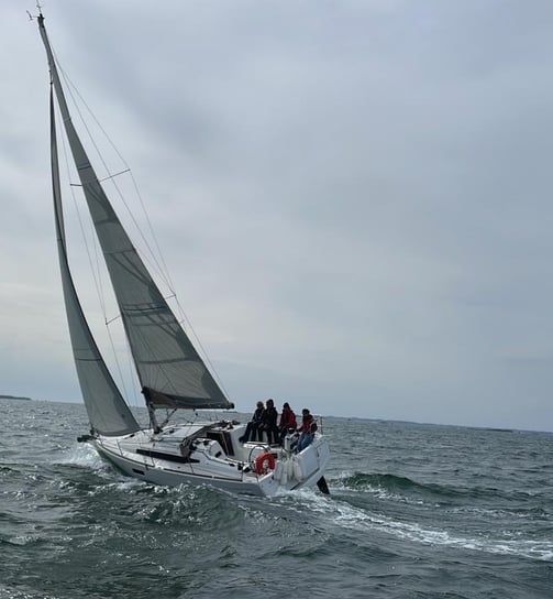 a sailboat with people on it in the ocean