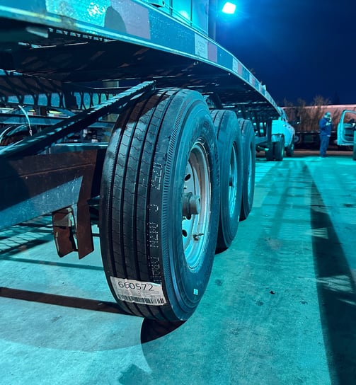 Close up view of new tires on a trailer in the blue night lights