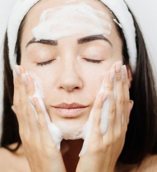 woman cleansing her face