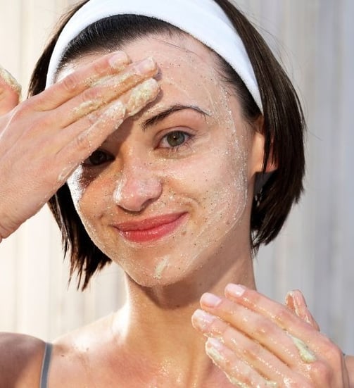 woman exfoliating her face