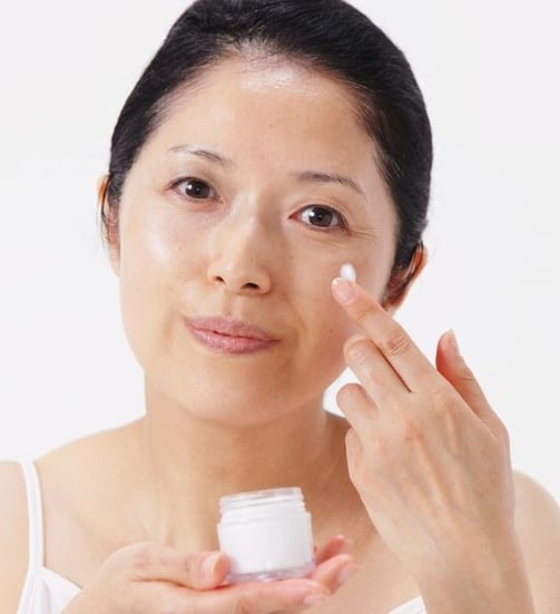woman moisturizing her face