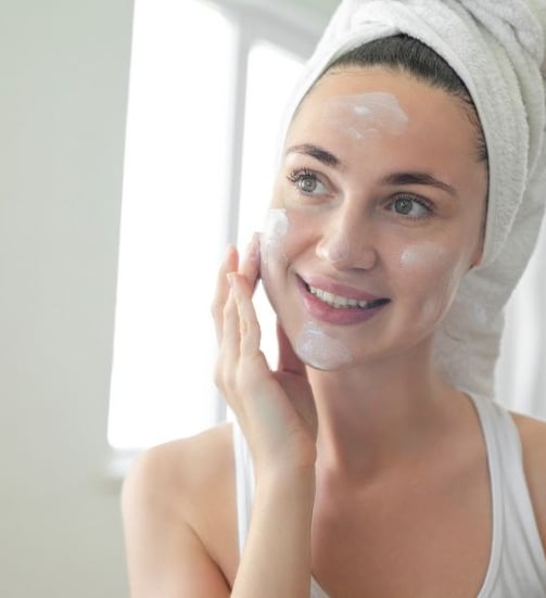 woman putting sunscreen on her face