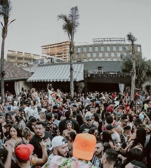 Large crowd at nightclub in with palm trees