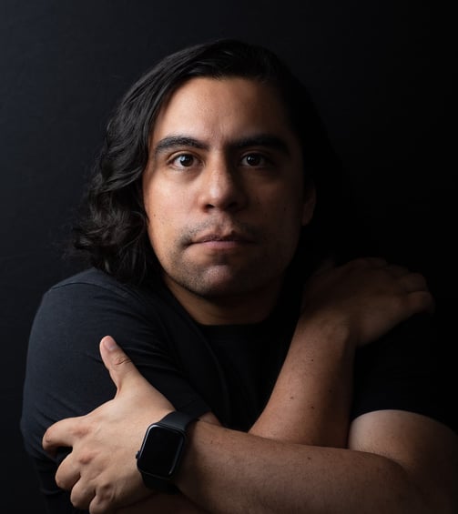 A man with long hair and a watch on his wrist