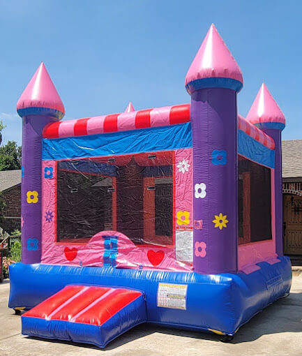 Pink flower bounce house rental in Oklahoma city backyard