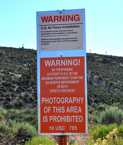 a warning sign posted on a sign post
