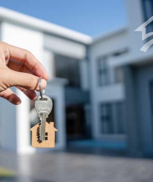 keys and a house in background
