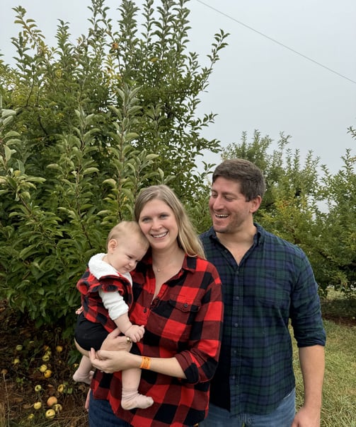 a man and woman standing in front of a tree