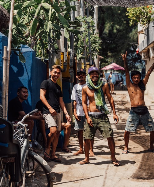a group of indonesian people standing around a bicycle
