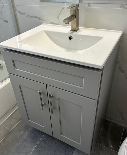 a bathroom sink with a white sink and a shower
