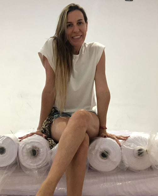 a woman sitting on a pile of rolls of toilet paper