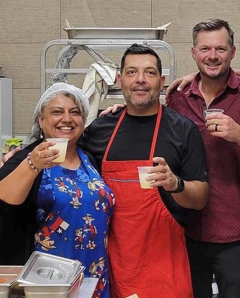 a group of people standing in a kitchen