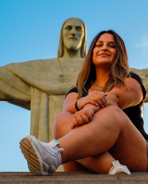 turista posando aos pés do cristo redentor