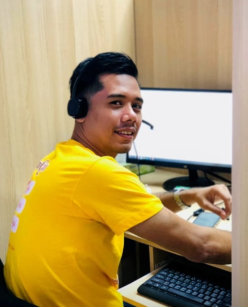 Dr Zaw wearing a headset looking back while working with a computer